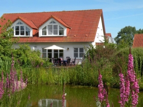 Blick vom Teich auf das Ferienhaus