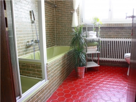 Das Badezimmer mit Dusche, Badewanne, Toilette und 2 separaten Waschbecken sowie einem großen Spiegel.