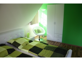 Das zweite, grüne Schlafzimmer bietet Ruhe und Entspannung. Selbstverständlich ist hier, wie auch in allen anderen Schlafzimmern, ein Flatscreenfernseher vorhanden.