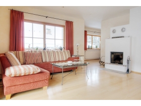 Exclusives Wohnzimmer mit Kamin und Zugang zum großen Balkon mit traumhaftem Panoramablick.